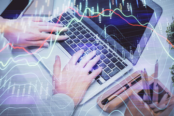 Multi exposure of woman hands typing on computer and forex chart hologram drawing. Stock market analysis concept.