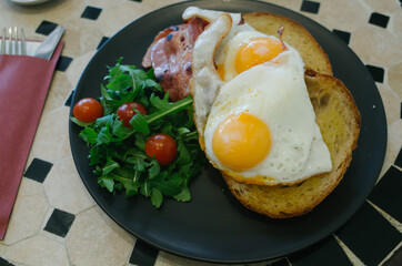 fried eggs with bacon and vegetables