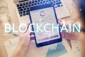 Double exposure of man's hands holding and using a phone and crypto currency blockchain theme...