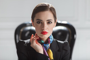 fashion caucasian model in black business suit sitting in chair