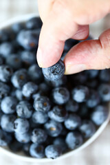 Selective focus. Macro. Blueberries in a man's hand. A man's hand holds blueberries.