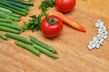 tomatoes green peas and parsel on table