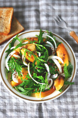 Selective focus. Macro. Healthy homemade salad with arugula and yellow tomato on a plate. Cooking healthy meals at home.