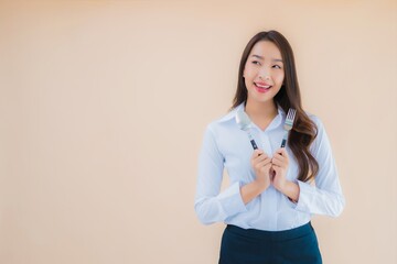 Portrait beautiful young asian business woman with spoon and fork