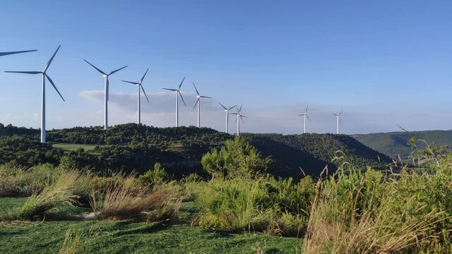Windturbines / Windmill  For Generation of Electricity , Electric Power.Energy Production With Clean and Renewable Energy .Mountains landscape view.