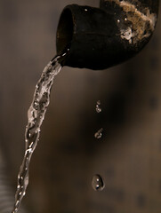 Water Dripping out as wastage  during morning routine in wash basin drainage hole with macro shot of water drops showing clear drops to maintain cleanliness in corona