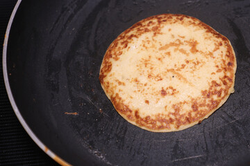 Banana Pan Cake garnished with Chocolate Syrup and Choclate Cube at the top served on white ceramic plate