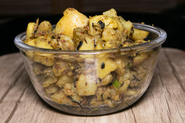 Boiled Potato mixed with Spices herbs like Mint and Cumin Powder Indian Tasty Cuisine Aloo Ki Sabji in Indian Homes filled in Transparent Glass Bowl Served with Wheat Bread macro shot