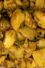 Boiled Potato mixed with Spices herbs like Mint and Cumin Powder Indian Tasty Cuisine Aloo Ki Sabji in Indian Homes filled in Transparent Glass Bowl Served with Wheat Bread macro shot