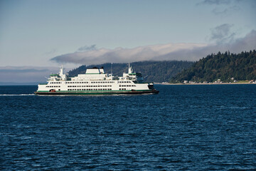 Fototapeta na wymiar 2020-08-01 A LARGE PASSENGER FERRY ALONG THE SHORELINE OF WHIDBEY ISLAND WITH CLOUD COVER MOVING IN