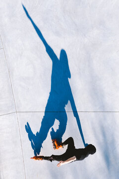 Aerial view of roller skater shadow silhouette on concrete surface.