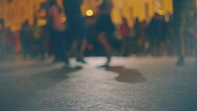 Defocused Street salsa dance in the night, many young couples dance social latino dances in slow motion