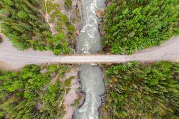 Drone shot of a isolated river and bridge located in northern Canada, Yukon Territory during the summer time. 