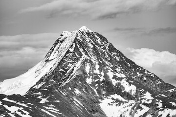 Stunning mountain landscape in the Yukon wilderness with cloudy sky. Taken in the summertime. Grayscale photo. 