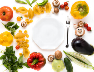 Background of plate, fork, pasta and vegetables.