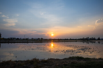 Obraz premium landscape with early sunrise by the lake, heaven sky, black tree silhouettes. Beautiful shadows and swamp river.