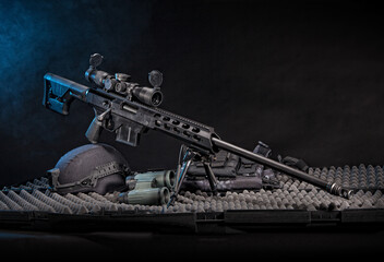 Sniper rifle with tactical gear, shot in studio with a black background.