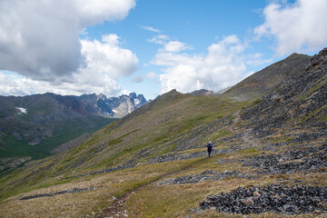 Fototapeta na wymiar Person hiking through spectacular Tombstone Territorial Park located in Northern Canada, Yukon Territory during the summertime. 