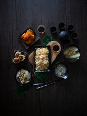 Chinese Food At Home. Chinese Dishes on Dark Background with Copy Space. Fried Rice and Chinese Food Flatlay on Wooden Table. Rustic, Home Cooked Dishes.