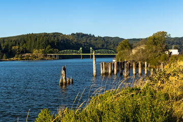 Fototapeta premium Landscape with a bridge over river in summer day. Millicoma river, Oregon
