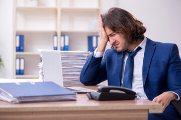 Young male employee unhappy with excessive work