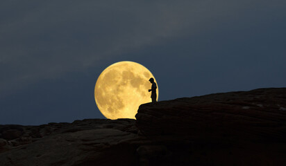 Big super moon and a man on the cliff in the early evening