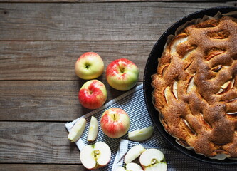 Round apple pie or sponge cake on wooden rustic table. Home cooking.