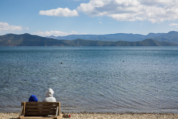 couple sitting on the edge of lake