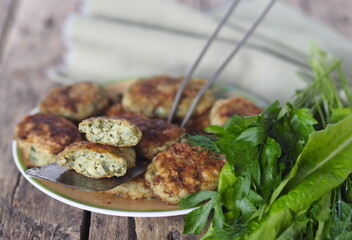 Healthy vegetarian and dietary food. Vegetable and fish cutlets with greens on a wooden background.