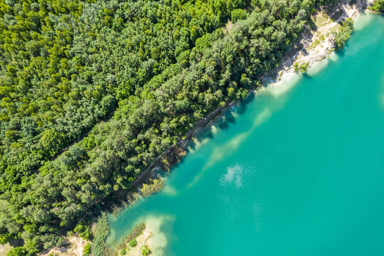 aerial top view of a calm quarry lake with coast covered by green forest. summer landscape © Mr Twister