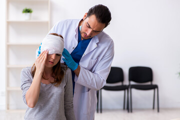 Obraz premium Young head injured woman visiting young male doctor