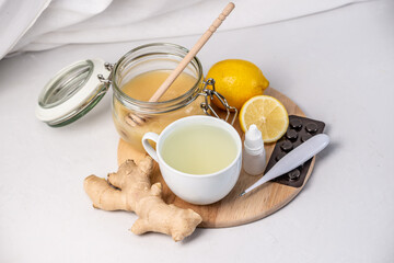 Hot tea with ginger, honey, lemon and preparations for cold and a thermometer. Concept of vitamin healthy tea for the sick