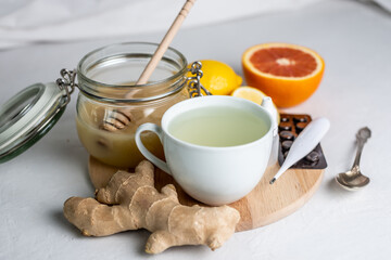 Hot tea with ginger, honey, lemon and preparations for cold and a thermometer. Concept of vitamin healthy tea for the sick