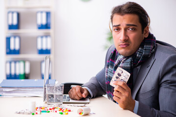 Young male employee suffering at workplace