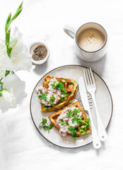 Savory zucchini waffles with tuna, cream cheese pate and coffee on a light background, top view. Delicious healthy breakfast, brunch, snack