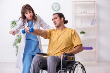 Young male patient in wheel-chair doing physical exercises