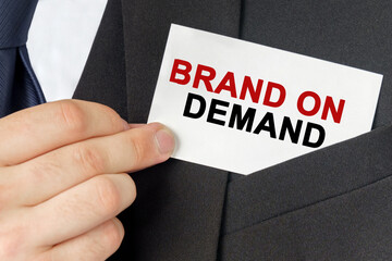 Businessman holds a card with the text - BRAND ON DEMAND