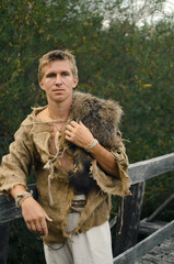 guy in a medieval burlap suit with an animal skin on his shoulder
