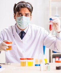 Young handsome chemist working in the lab