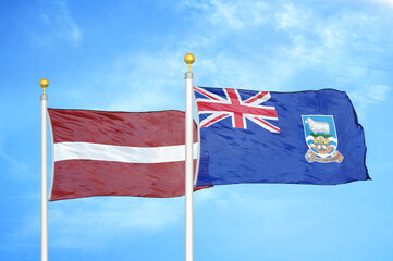 Latvia and Falkland Islands two flags on flagpoles and blue sky