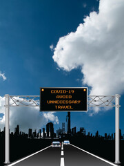 Roadway overhead digital gantry sign with COVID 19 Coronavirus avoid unnecessary travel message set against a blue cloudy sky 