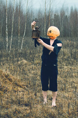 man in ragged clothes with a Halloween lantern lost in the autumn forest. scary story