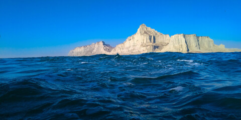 Fototapeta na wymiar Blue deep sea with big mountains