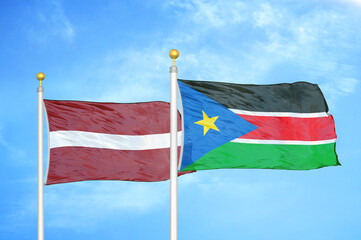 Latvia and South Sudan two flags on flagpoles and blue sky