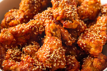Korean fried chicken with sesame grain topping and marinated with gochujang chili paste 

