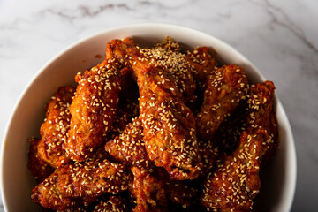 Korean fried chicken with sesame grain topping and marinated with gochujang chili paste 

