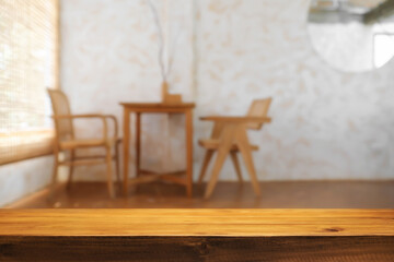 Empty wooden desk space and blurry background of coffee shop or Restaurant for product display montage.