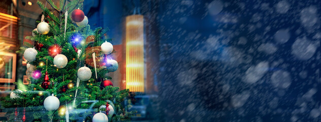 雪の降る街のショーウインドウに飾られたクリスマスツリー