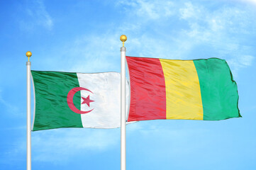Algeria and Guinea two flags on flagpoles and blue sky
