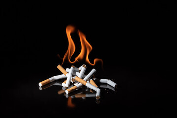 Bonfire of cigarettes in the dark. Concept of harm of smoking